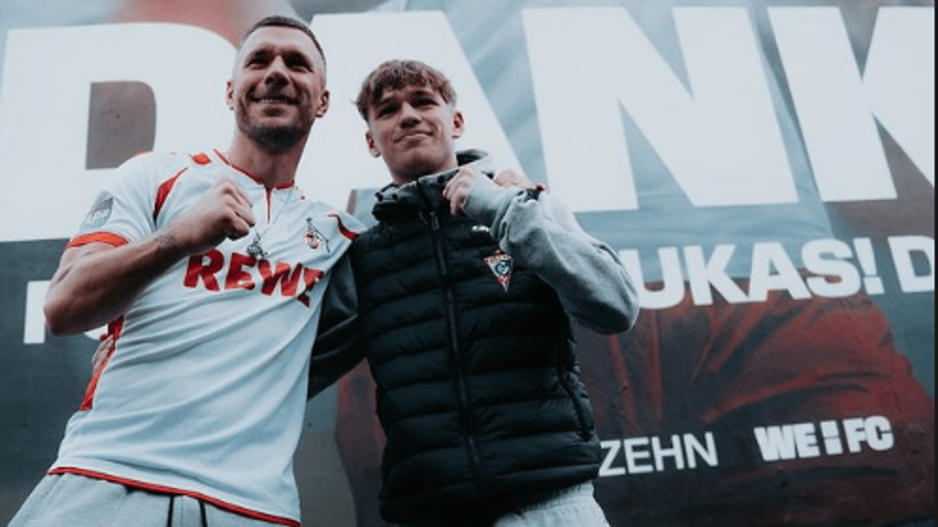 Lukas Podolski posiert gemeinsam mit seinem Sohn Louis vor einem Mural im Kölner Stadtteil Ehrenfeld. Der 1. FC Köln hatte die Wand extra zum Abschied von Podolski bemalt.