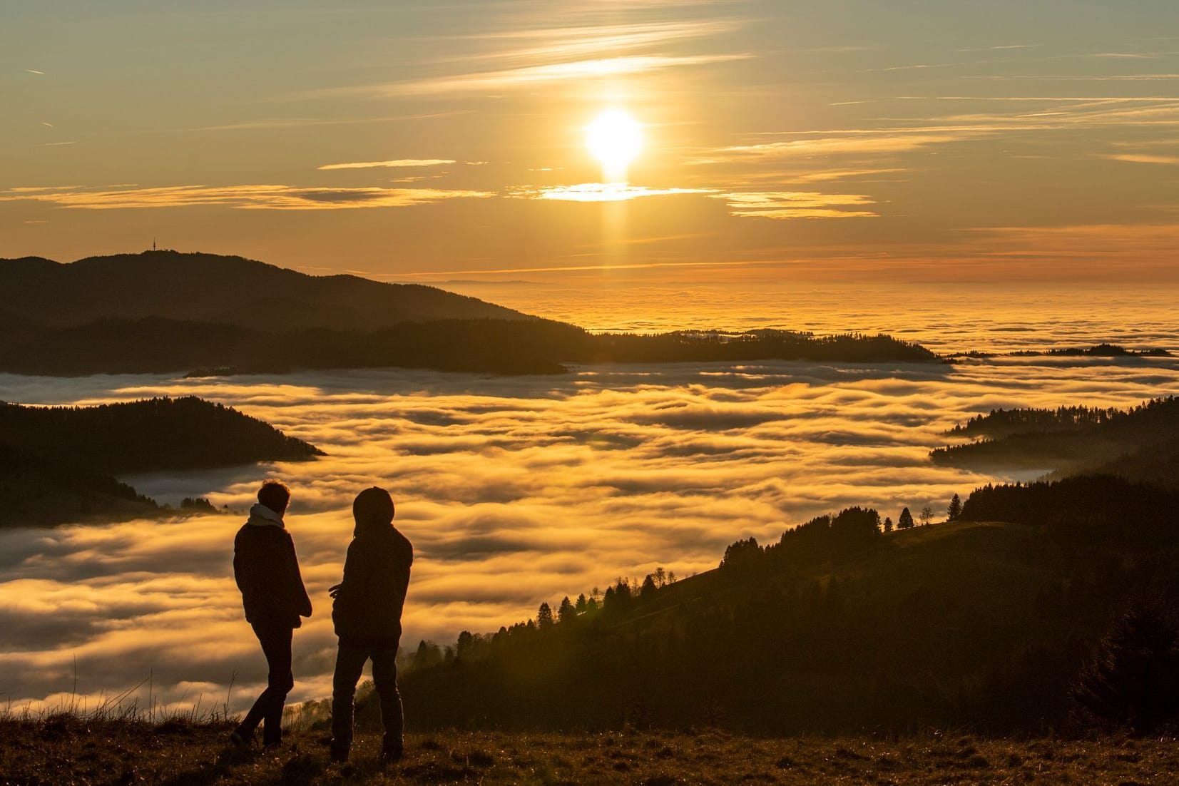 Zwei Spaziergänger betrachten den Sonnenuntergang