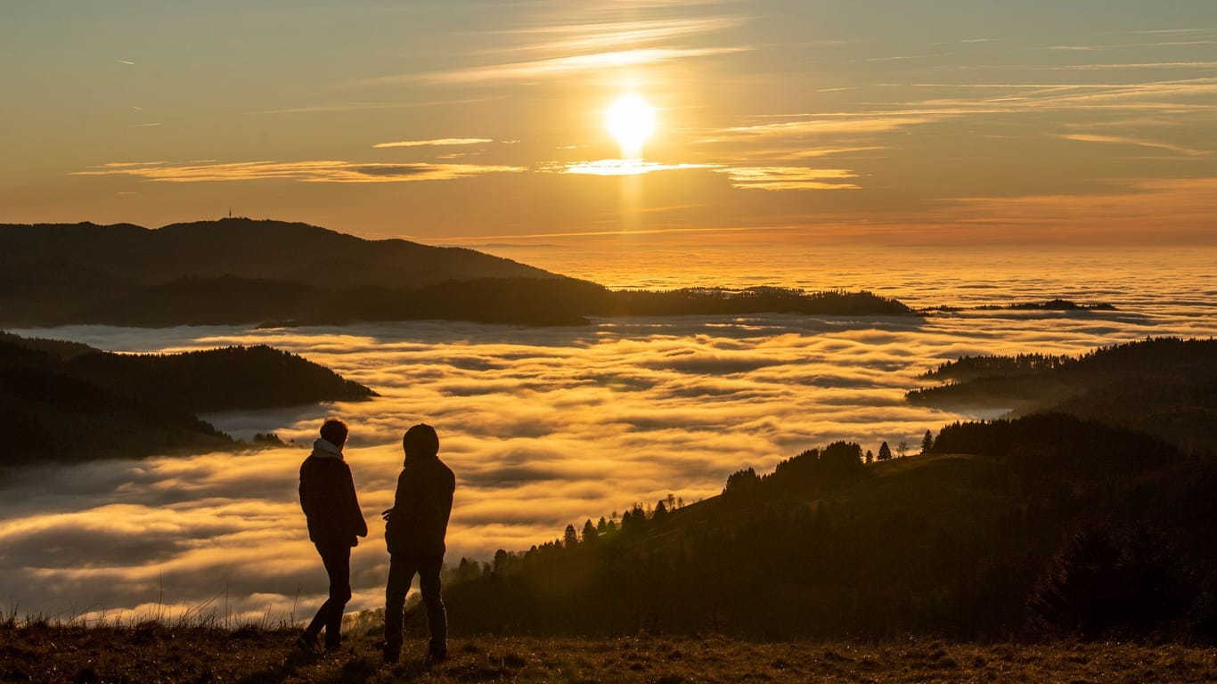 Zwei Spaziergänger betrachten den Sonnenuntergang