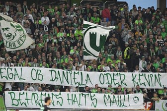 Fans vom VfL Wolfsburg zeigen ein Banner "Egal ob Daniela oder Kevin, Behrens halt's Maul".