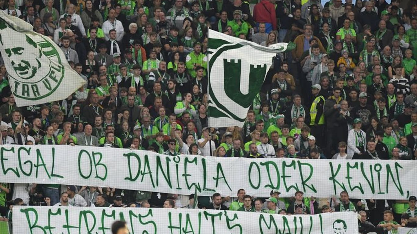 Fans vom VfL Wolfsburg zeigen ein Banner "Egal ob Daniela oder Kevin, Behrens halt's Maul".