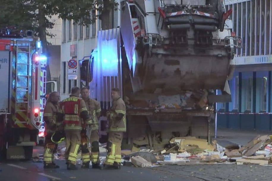 Feuerwehrleute stehen neben einem Müllfahrzeug: Mitte Oktober ist darin ein 33 Jahre alter Mann tot aufgefunden worden.