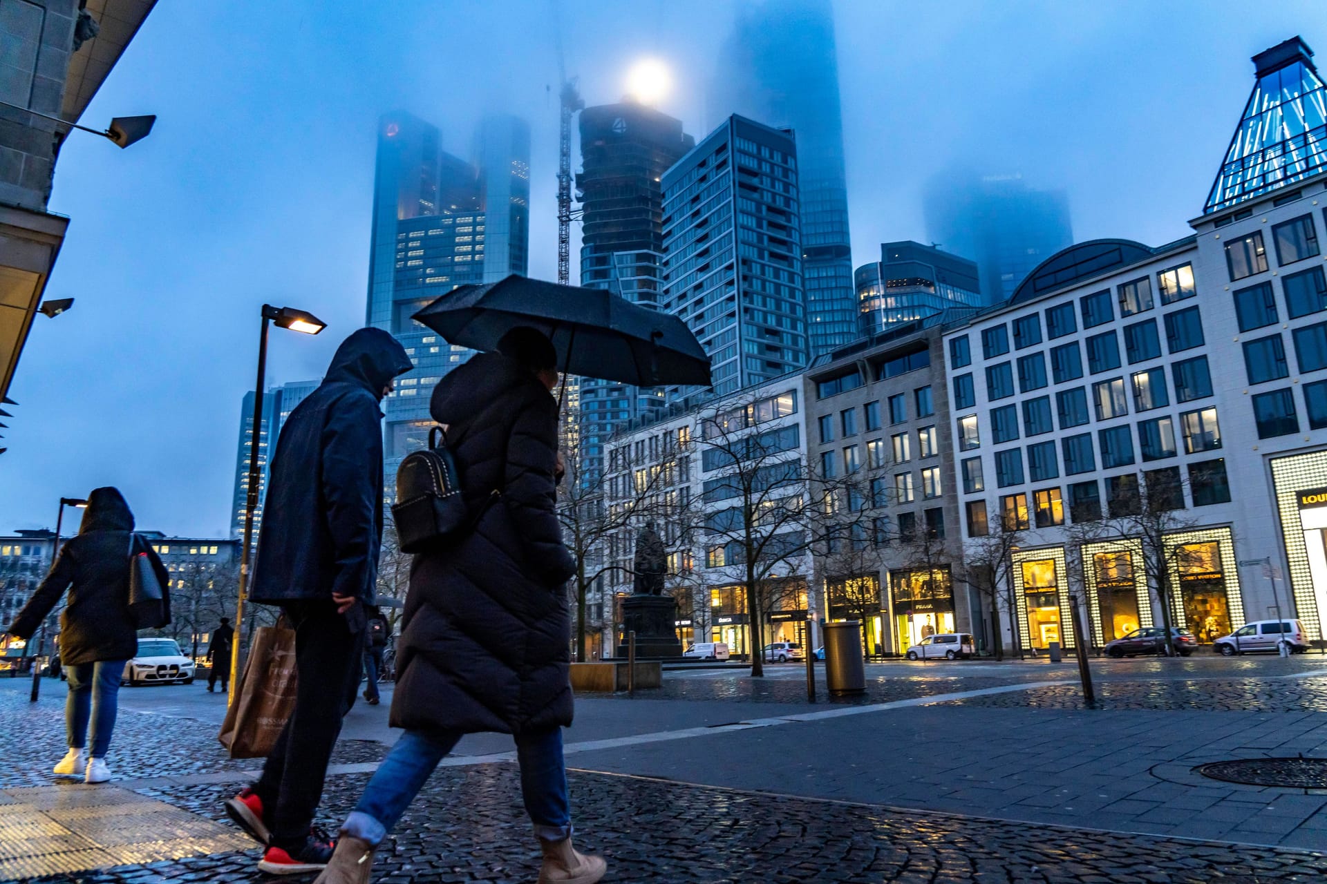 Menschen laufen bei Regen durch Frankfurt (Archivbild):