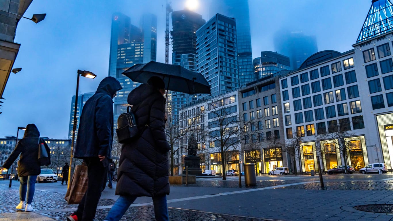 Menschen laufen bei Regen durch Frankfurt (Archivbild):