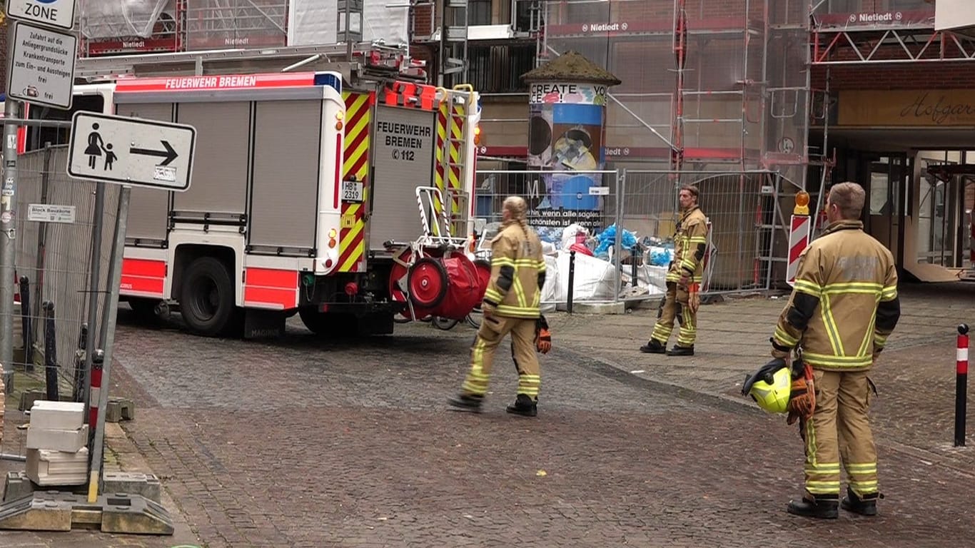 Rettungskräfte stehen an der Unfallstelle: Zwei Arbeiter sind in Bremen von einem Gerüst gefallen.