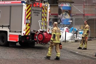 Rettungskräfte stehen an der Unfallstelle: Zwei Arbeiter sind in Bremen von einem Gerüst gefallen.