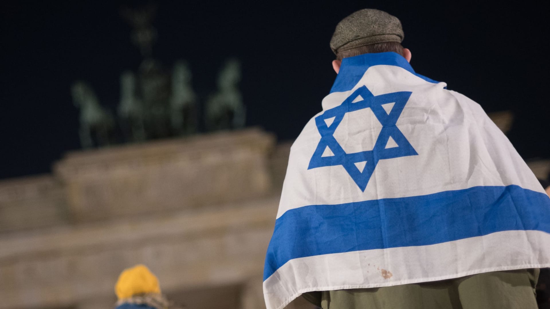 Israel-Flagge am Brandenburger Tor: Teilnehmer einer Mahnwache, bei der Namen der Opfer des Massakers der Hamas am 7. Oktober 2023 vorgelesen werden