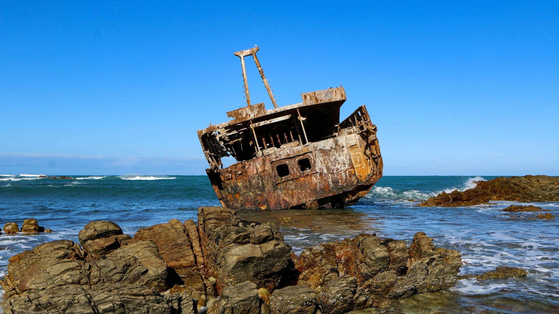 Ein rostiges Schiff liegt vor dem Kap Agulhas in Südafrika.