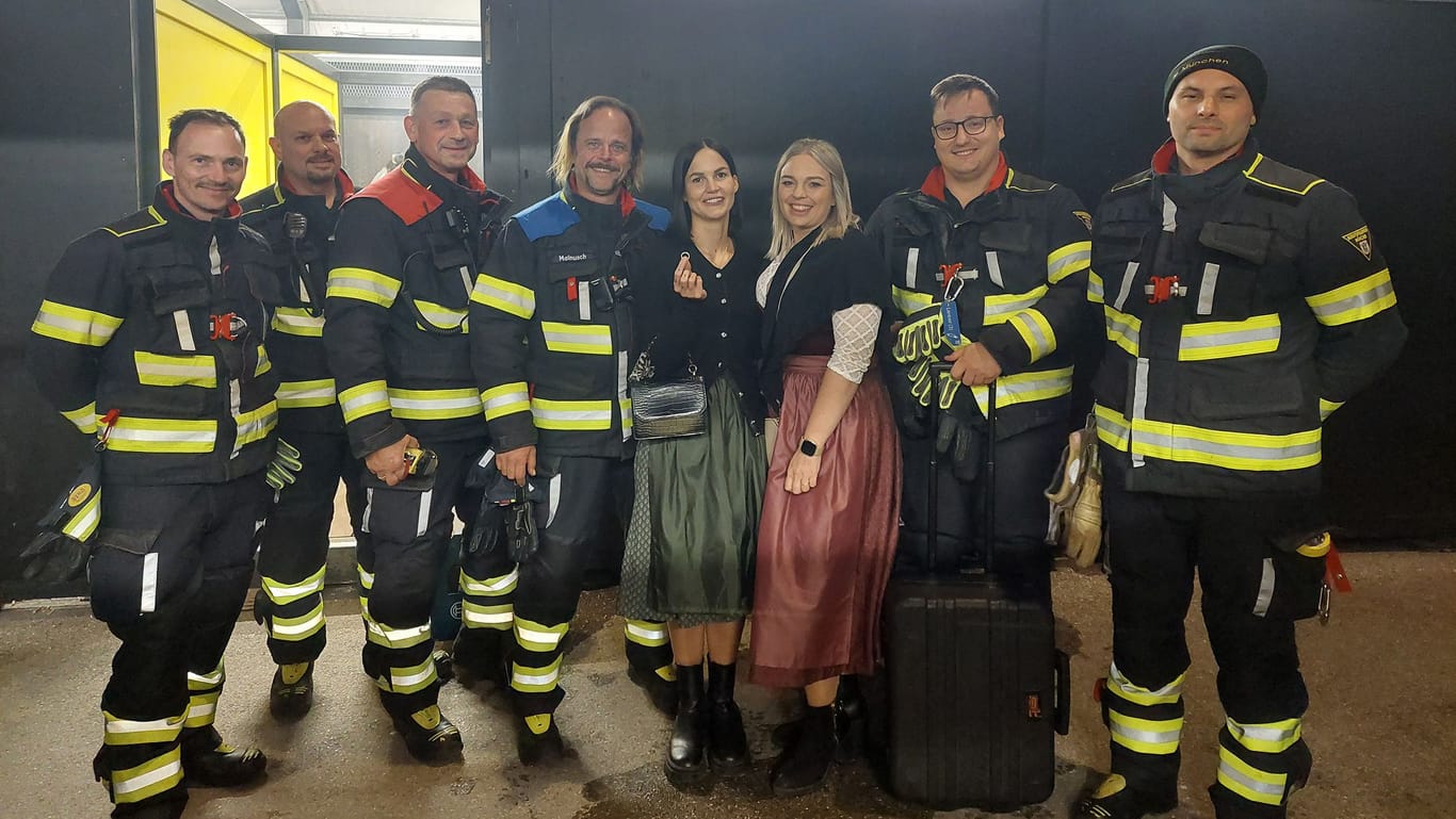 Die Münchner Feuerwehr mit der glücklichen Besitzerin des Eherings und ihrer Freundin.