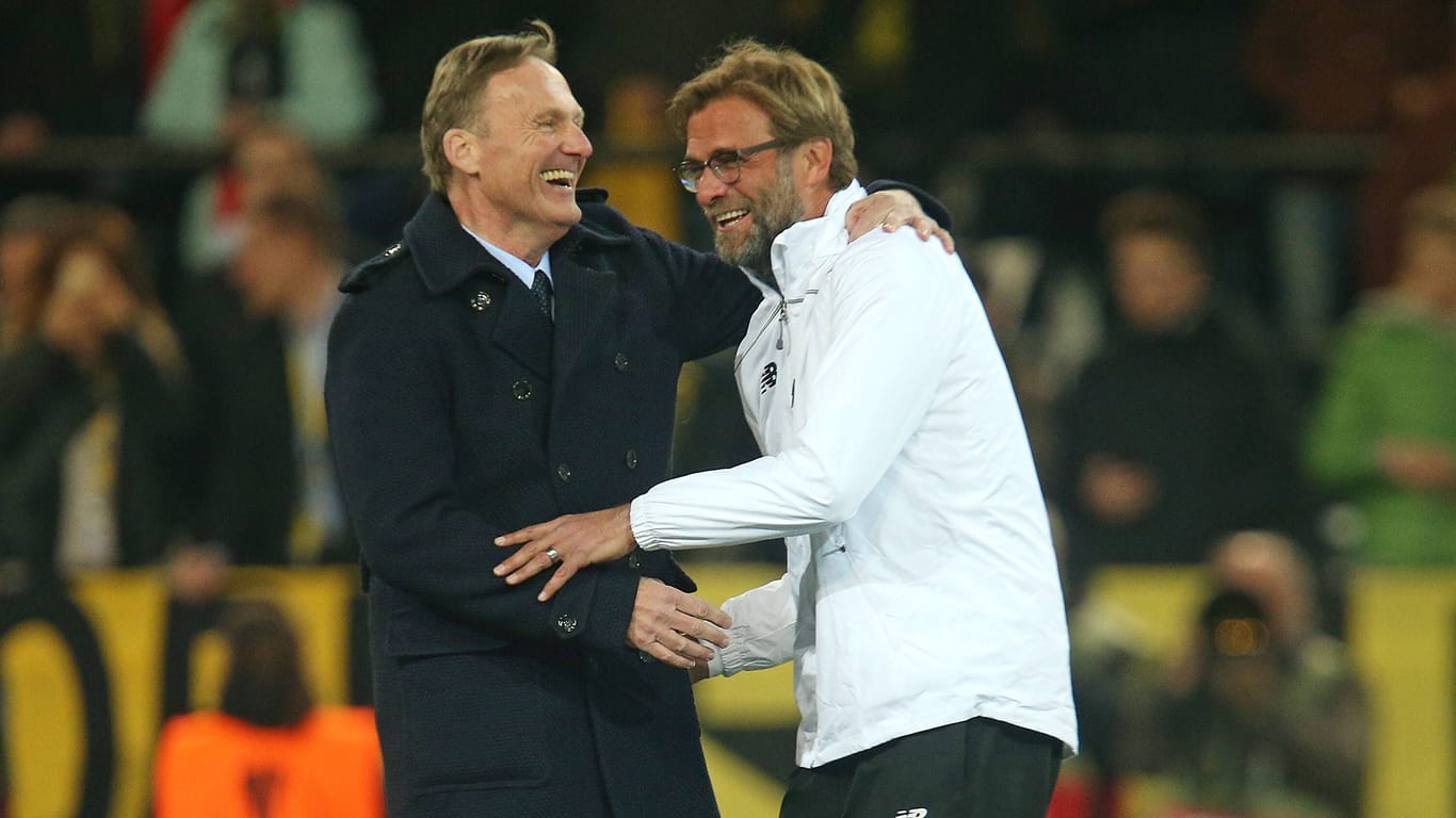 BVB-Geschäftsführer und Liverpool-Trainer Jürgen Klopp, der lange für Borussia Dortmund gearbeitet hat, treffen sich nach einem Fußballspiel in einem Stadion und lachen gemeinsam.