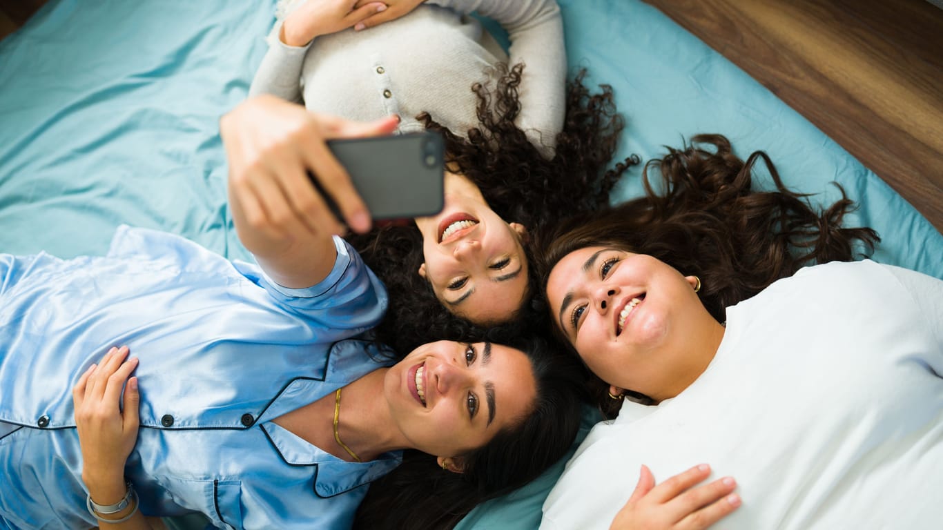 Cheerful best friends laughing having fun at a slumber party