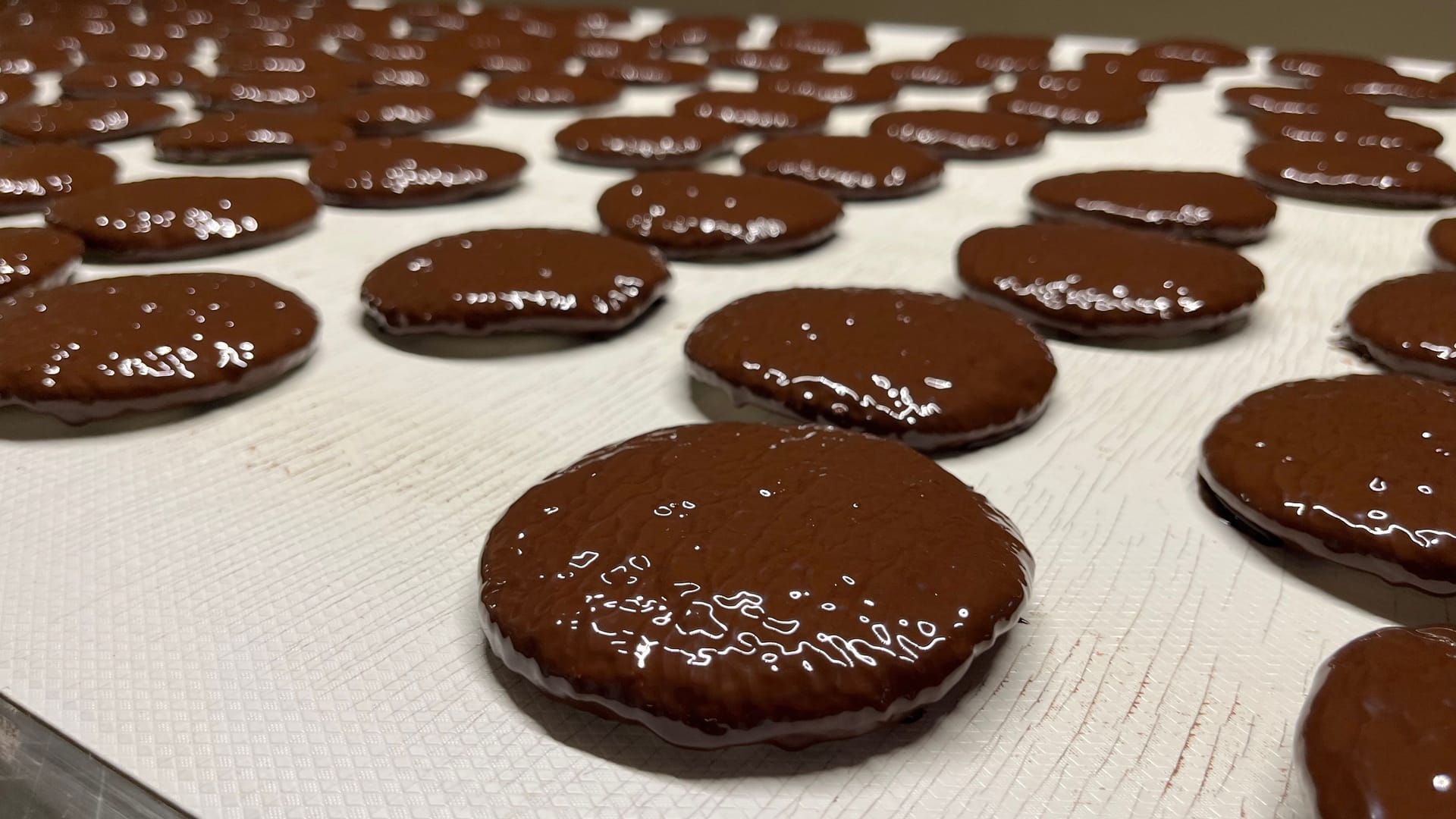 Die frisch mit Schokolade überzogenen Lebkuchen: Das Band führt sie danach noch durch eine eigene Station zum Auskühlen und schließlich zur Qualitätskontrolle.