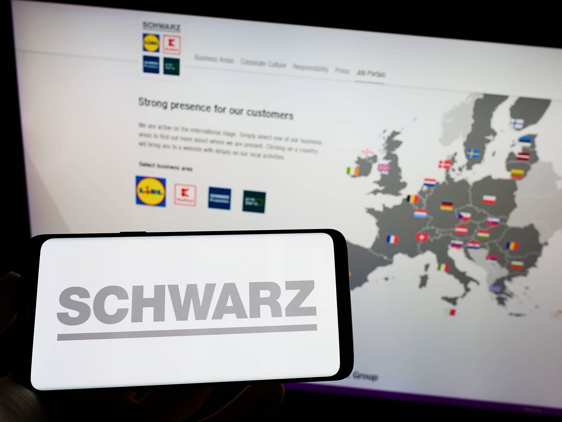 Ein Handy mit dem Namen "Schwarz" vor einer Website mit Standorten von Kaufland und Lidl: Der reichste Deutsche meidet die Öffentlichkeit.