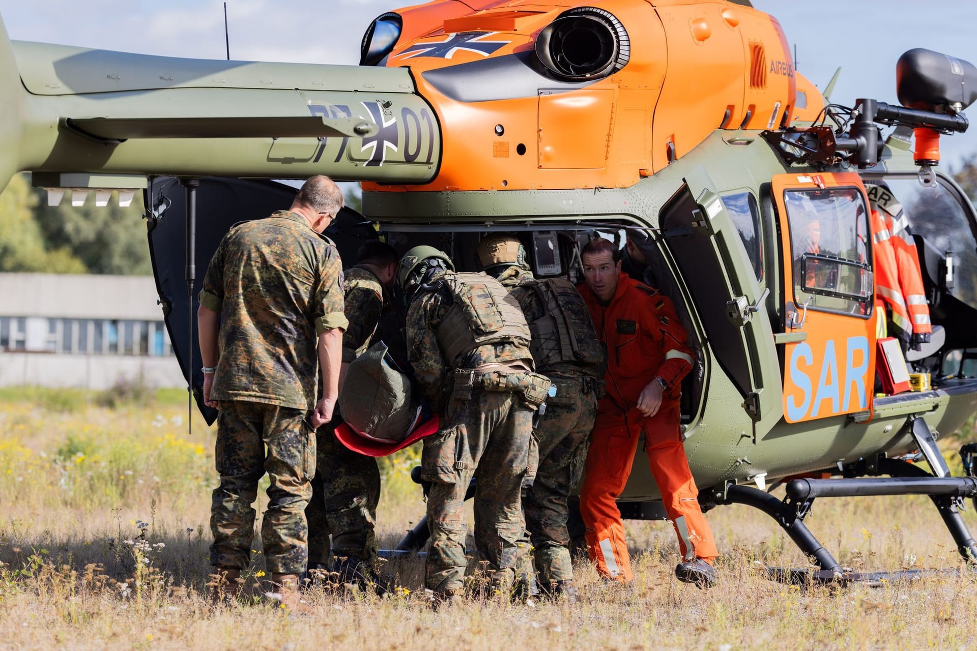 Bundeswehrsoldaten des Such- und Rettungsdienstes der Bundeswehr überführen einen fiktiven Verletzten zu einem Rettungshubschrauber. Bei der Übung gab es aber auch tatsächlich Verletzte.