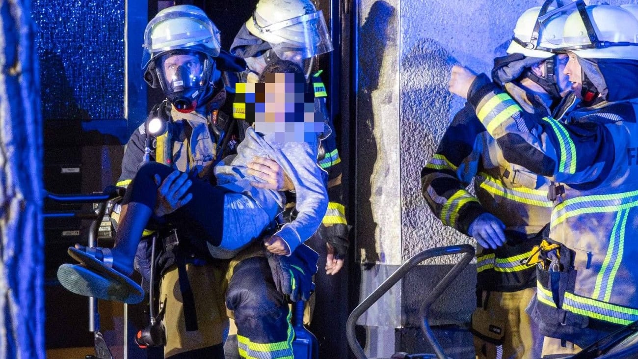 Feuerwehrleute retten ein Mädchen aus einem Haus in Katernberg am Donnerstagabend.