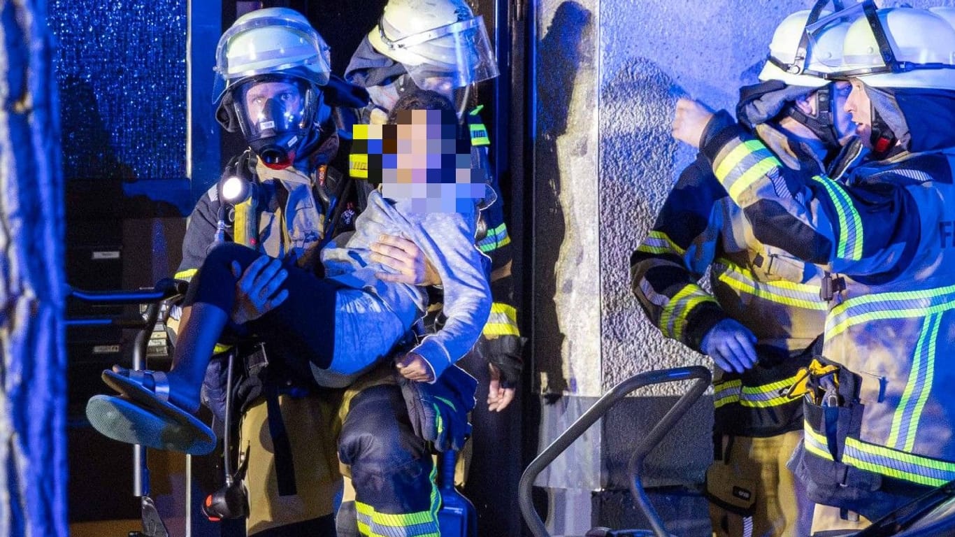 Feuerwehrleute retten ein Mädchen aus einem Haus in Katernberg am Donnerstagabend.