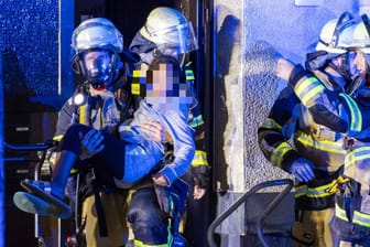 Feuerwehrleute retten ein Mädchen aus einem Haus in Katernberg am Donnerstagabend.