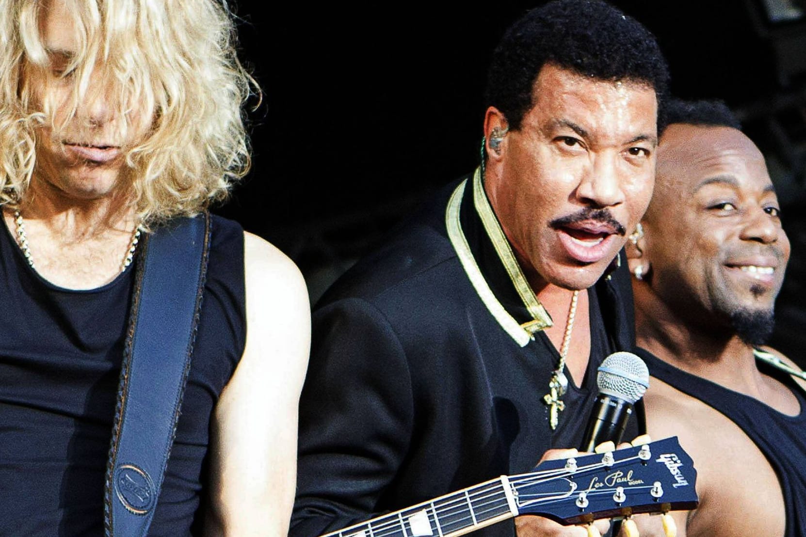 Lionel Richie (m.) steht zwischen zwei seiner Musiker beim Stadtpark Open Air auf der Freilichtbühne im Stadtpark Hamburg. (Archivbild von 2016)