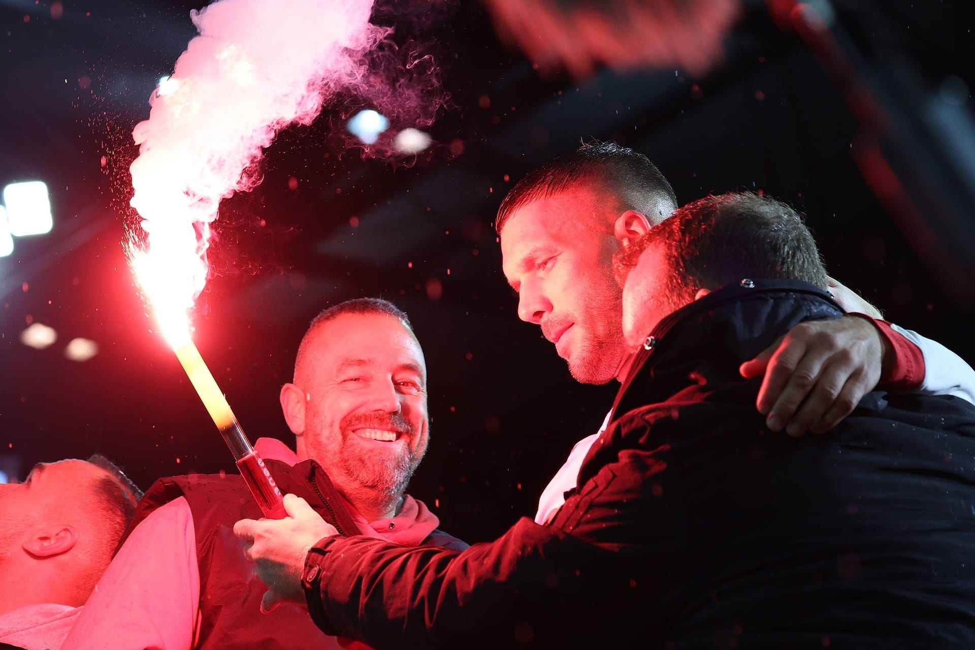 Lukas Podolski (Mitte) zwischen den Kölner Fans mit einer Pyrofackel.