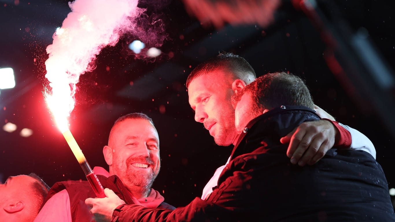 Lukas Podolski (Mitte) zwischen den Kölner Fans mit einer Pyrofackel.