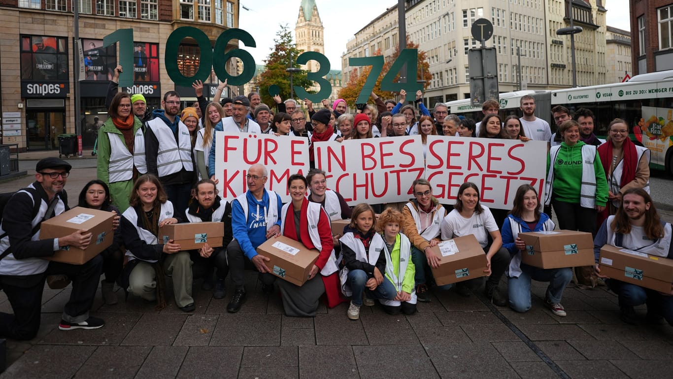 Vertreterinnen und Vertreter der Volksinitiative "Hamburger Zukunftsentscheid" stehen vor der Unterschriften-Übergabe auf der Mönckebergstraße in der Innenstadt.