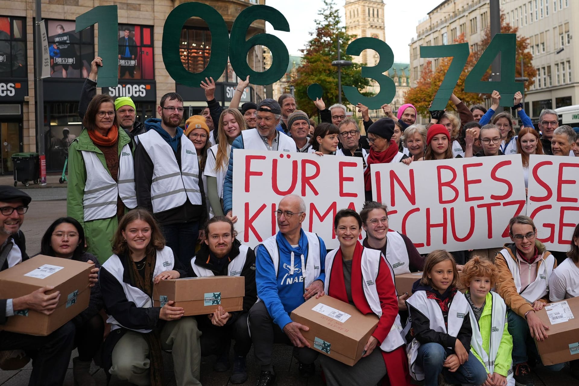 Vertreterinnen und Vertreter der Volksinitiative "Hamburger Zukunftsentscheid" stehen vor der Unterschriften-Übergabe auf der Mönckebergstraße in der Innenstadt.