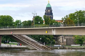 Brückenteile der teileingestürzten Carolabrücke liegen in der Elbe im Wasser, im Hintergrund ist das Rathaus zu sehen.