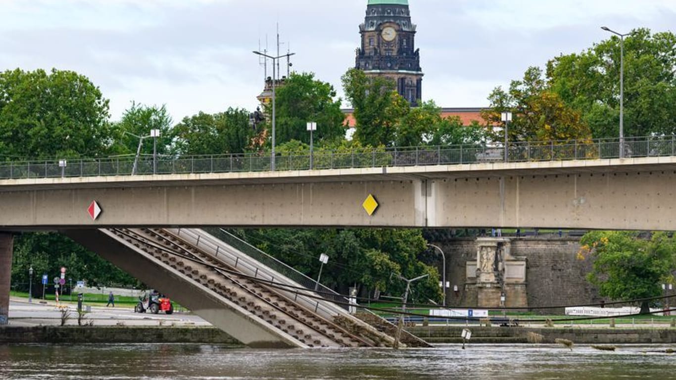 Brückenteile der teileingestürzten Carolabrücke liegen in der Elbe im Wasser, im Hintergrund ist das Rathaus zu sehen.