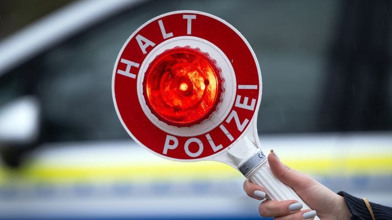 ARCHIV - 22.03.2024, Brandenburg, Trebbin: Eine Polizistin hält während einer Verkehrskontrolle an der Berliner Straße eine Polizeikelle mit der Aufschrift "Halt Polizei".