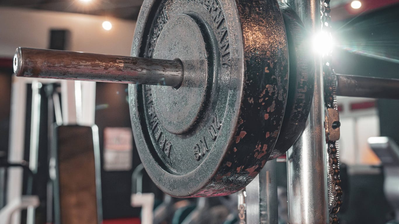 Eine Hantelstange in einem Fitnessstudio (Archivbild): Ein Mann in England starb bei einem Unfall mit einem Fitnessgerät.