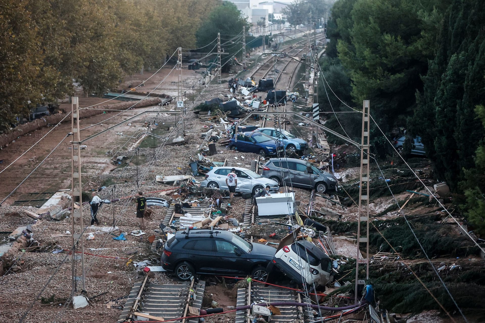 Autos, die durch das heftige Unwetter weggeschwemmt wurden, stehen auf den Gleisen.