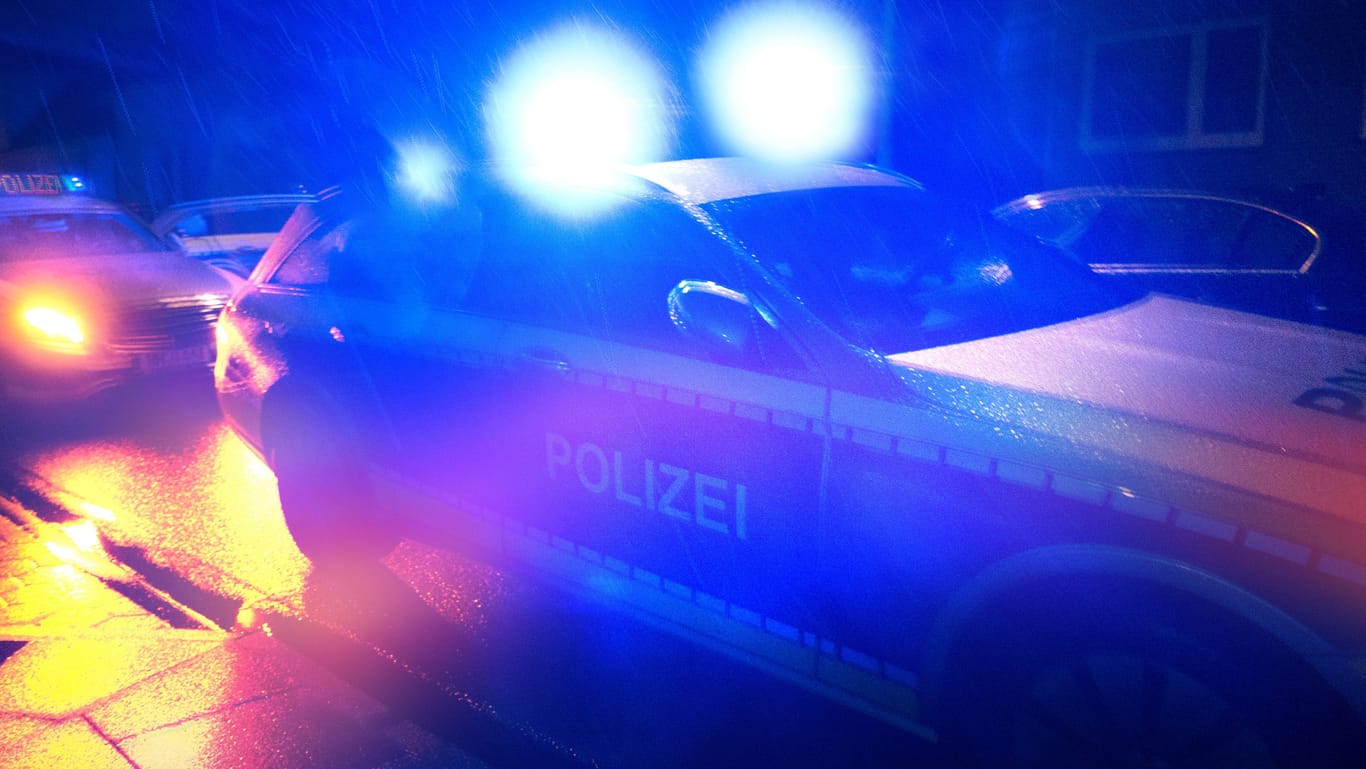 Polizeiwagen in der Nacht (Symbolbild): Eine Berliner Clan-Aussteigerin soll brutal angegriffen worden sein.