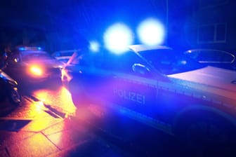 Polizeiwagen in der Nacht (Symbolbild): Eine Berliner Clan-Aussteigerin soll brutal angegriffen worden sein.