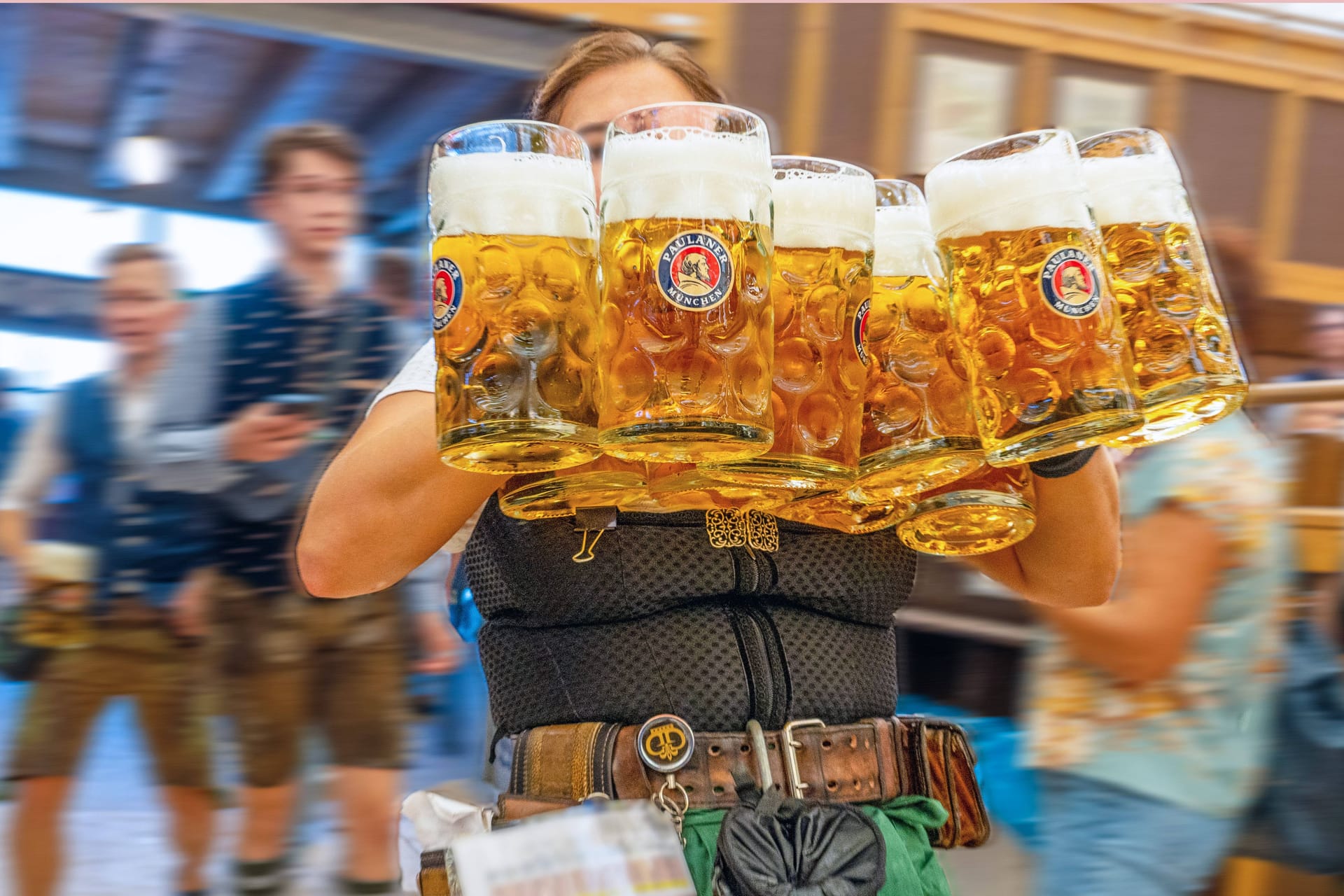 Eine Bedienung auf dem Oktoberfest trägt mehrere Maß Bier (Archivbild): Für die Speisen und Getränke gehen die Kellner meist in Vorkasse.