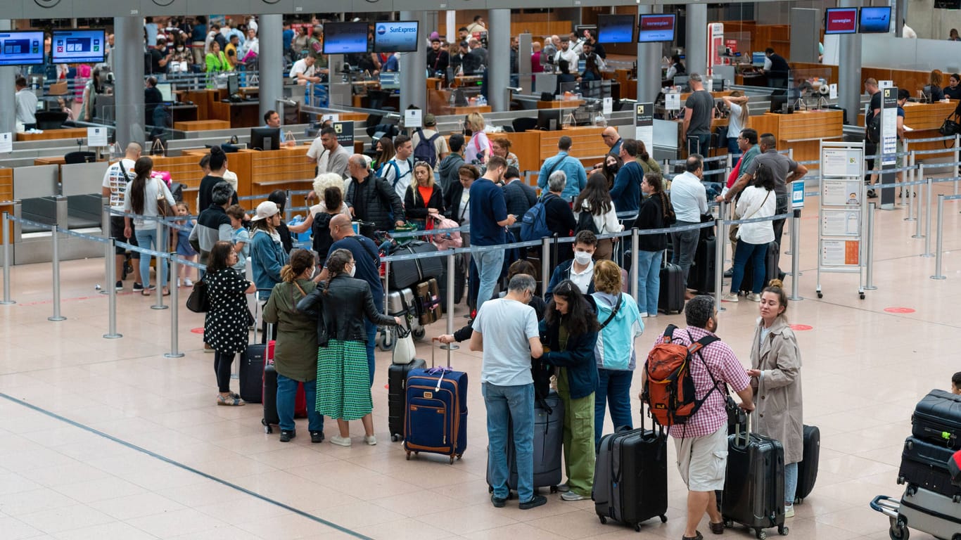 Reisende warten am Schalter am Hamburger Flughafen. (Archivbild)