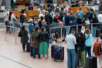 Reisende warten am Schalter am Hamburger Flughafen. (Archivbild)