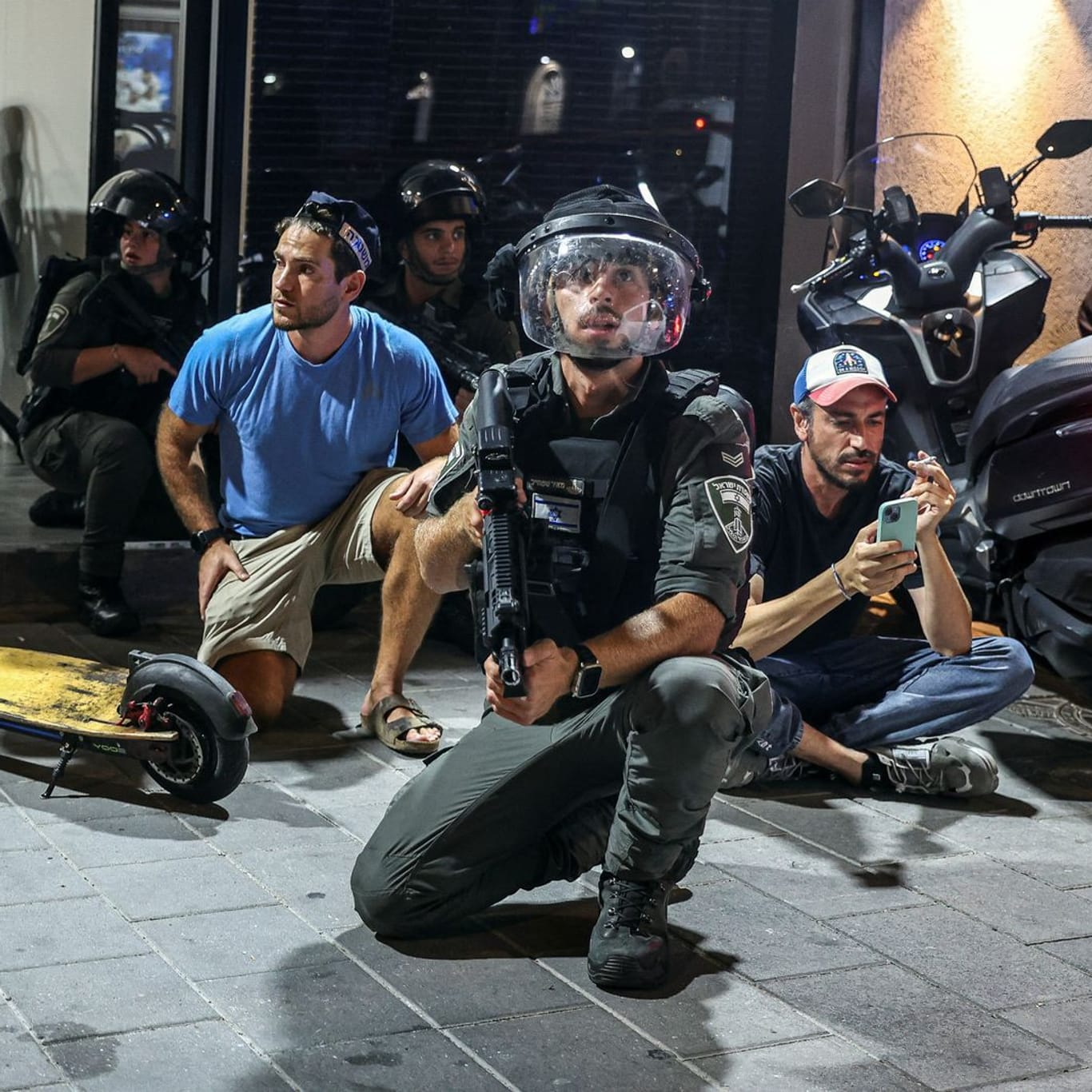 Tel Aviv: Israelische Polizisten und Soldaten gehen nach dem Luftalarm wegen der iranischen Raketen in Deckung.