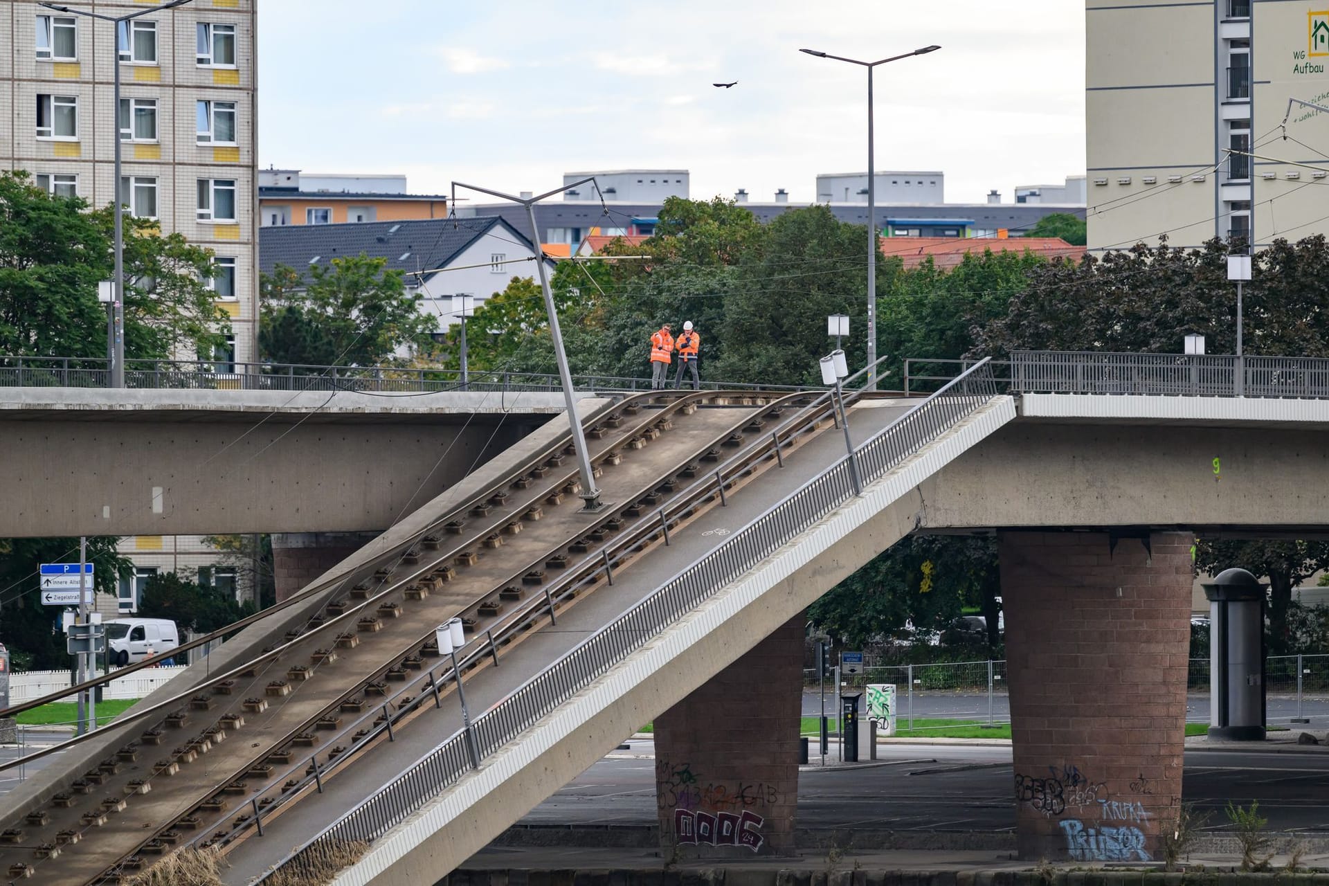 Fachleute stehen auf dem nichteingestürzten Teil der Carolabrücke und schauen auf den eingestürzten Brückenteile: