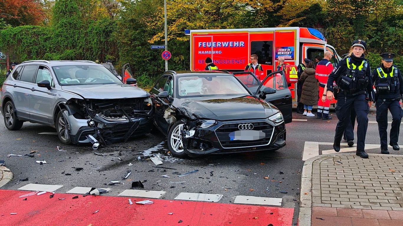 Polizisten und Rettungskräfte stehen neben den Unfallautos: In Öjendorf sind mehrere Menschen am Mittwoch verletzt worden.