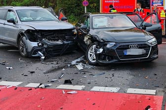 Polizisten und Rettungskräfte stehen neben den Unfallautos: In Öjendorf sind mehrere Menschen am Mittwoch verletzt worden.