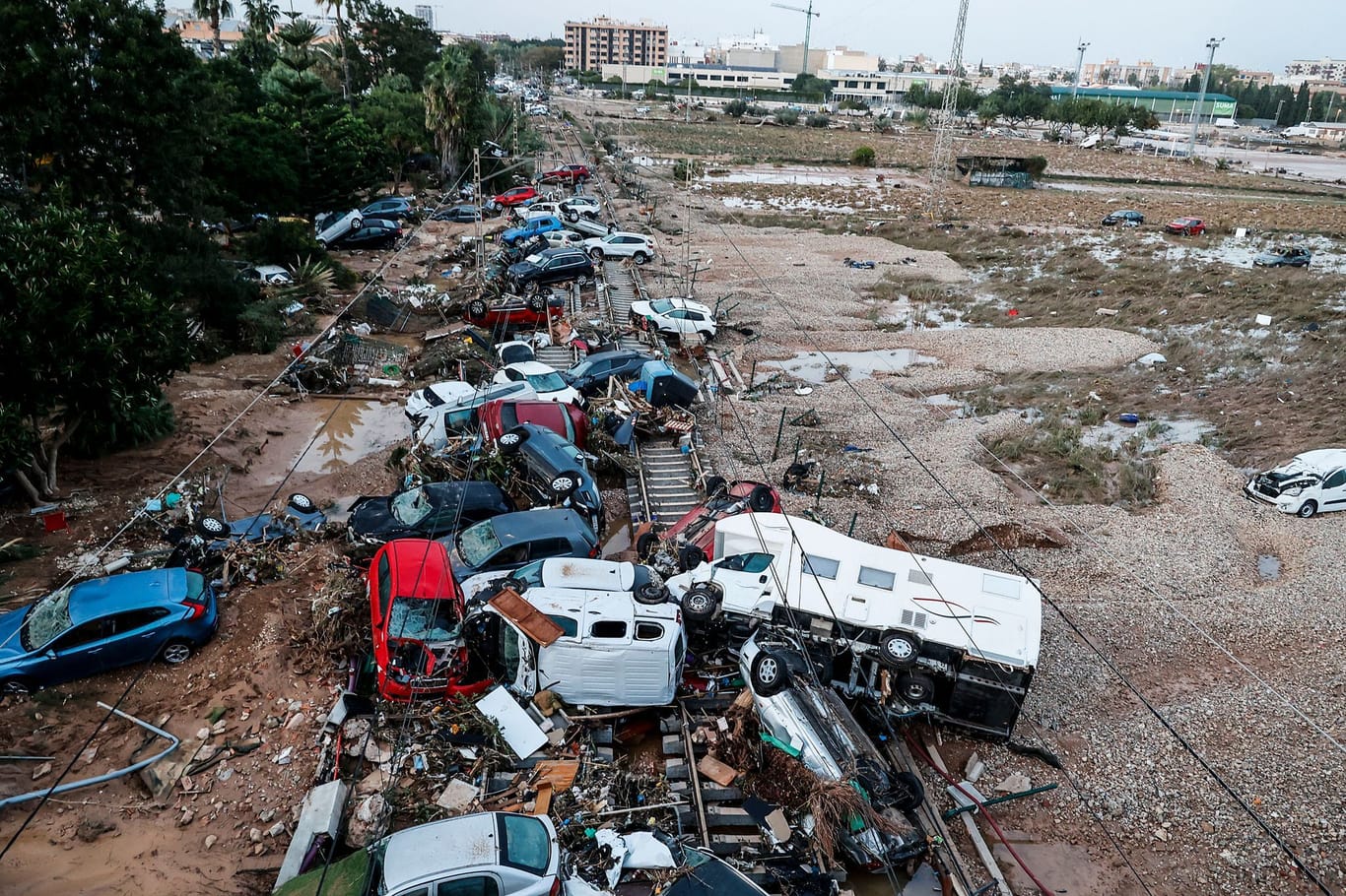 Valencia (valencianische Gemeinschaft): Autos, die durch das heftige Unwetter weggeschwemmt wurden, stehen auf den Gleisen.