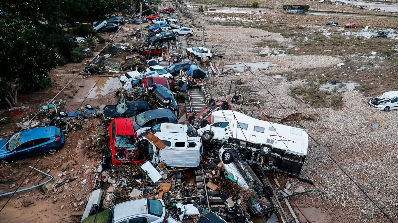 Valencia (valencianische Gemeinschaft): Autos, die durch das heftige Unwetter weggeschwemmt wurden, stehen auf den Gleisen.