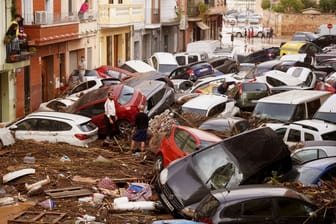 Verwüstungen nach schweren Unwettern in Spanien: Anwohner betrachten durch die Wassermassen aufgestapelte Autos.