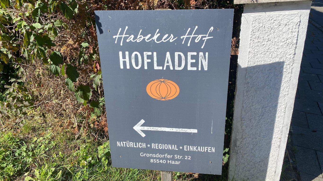 Ein Schild vor dem Hofeingang weist den Weg zu den Kürbissen.