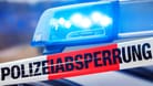 Absperrband vor einem Streifenwagen mit Blaulicht (Symbolbild): Die Polizei rückte mit einem Großaufgebot an.