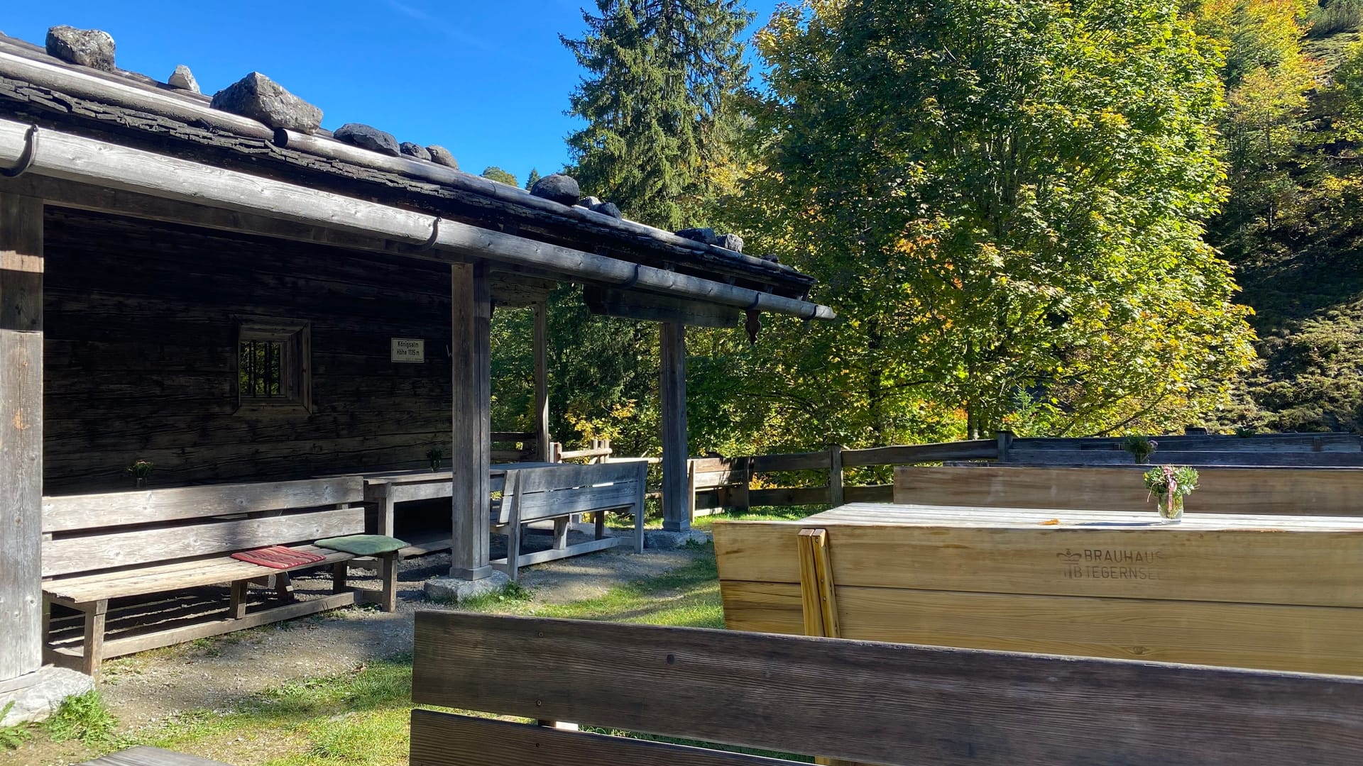 Zahlreiche Holzbänke vor der Königsalm laden zum Verweilen ein.