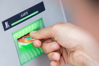 Eine Kundin bedient einen Geldautomaten (Symbolbild): Manche Bank-Kunden könnten kein Bargeld am Automaten bekommen.