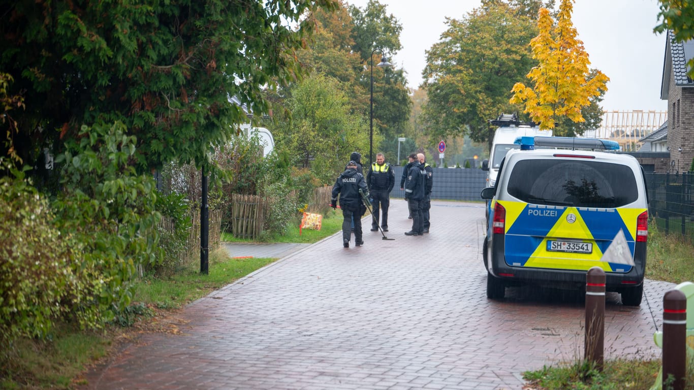 Einsatzkräfte der Polizei am Tatort: Die Kugeln trafen das Auto und das Haus, nicht aber den Mann.