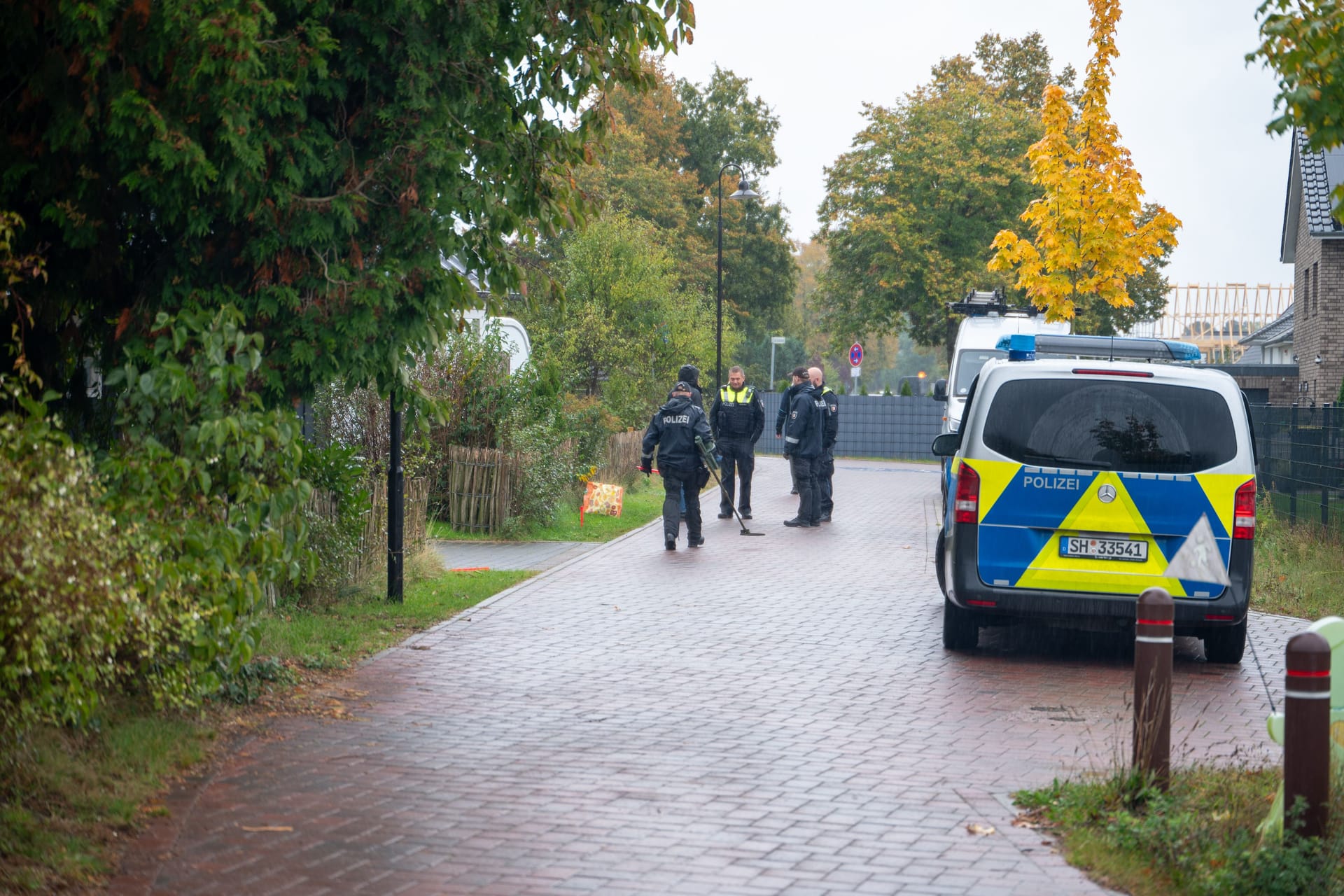 Einsatzkräfte der Polizei am Tatort: Die Kugeln trafen das Auto und das Haus, nicht aber den Mann.