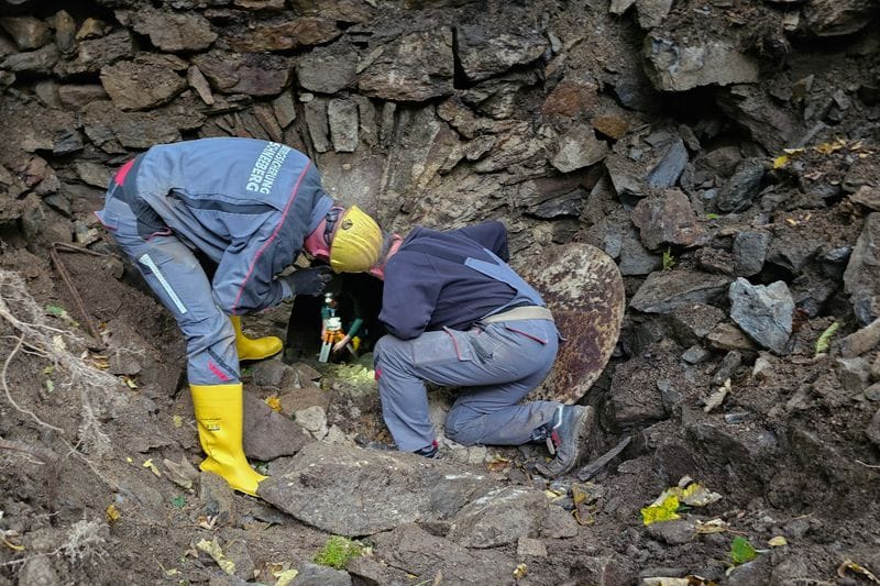 Mitarbeiter einer Firma zur Bergsicherung arbeiten in einem Areal in einem Waldstück. Ein in einem alten Bergwerksstollen im Erzgebirge mutmaßlich verschwundener Mann blieb vermisst. (Archivbild)